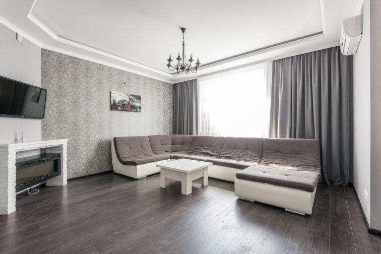 Elegant and modern living room interior featuring a large sectional sofa and natural light.