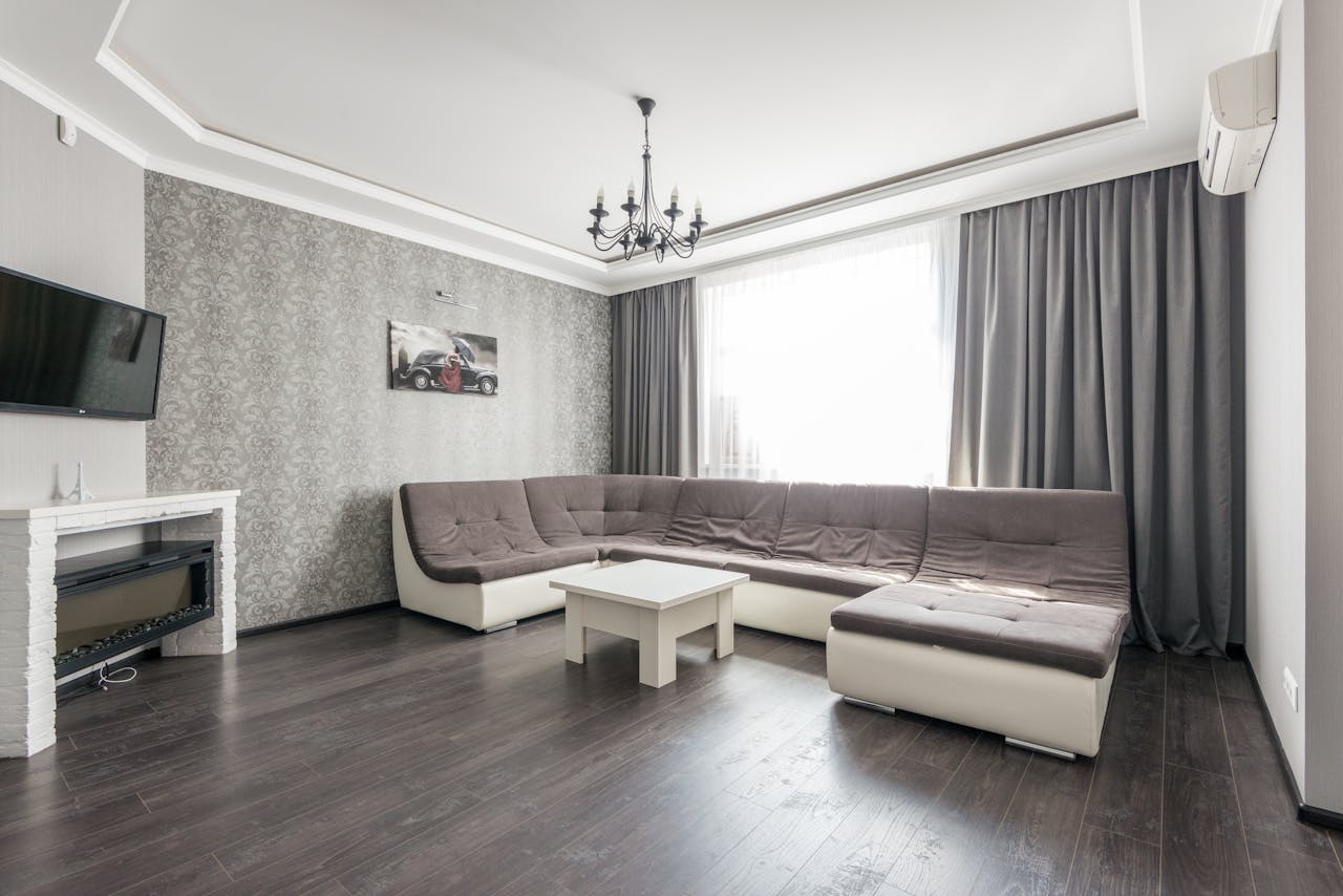 Elegant and modern living room interior featuring a large sectional sofa and natural light.